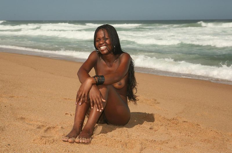 black girl with long hair posing on the beach
