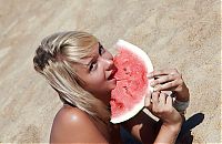 Babes: young blonde girl on the beach eating a watermelon