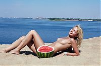 Babes: young blonde girl on the beach eating a watermelon