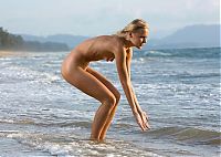 Babes: young blonde girl on the beach shows off her body in sea waves