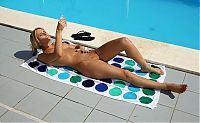 Nake.Me search results: blonde girl on the towel strips her bikini and sunbathing at the swimming pool