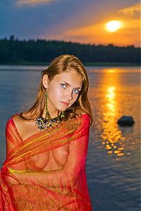 Babes: cute young golden blonde girl with blue eyes reveals on the bank of the lake during sunset