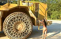 Babes: young black haired girl posing with heavy construction equipment vehicles of various types