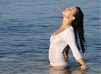 Babes: black haired girl undresses her white wet shirt in the sea