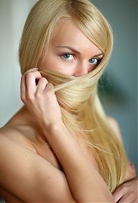 Babes: cute young blonde girl with blue eyes reveals her fringe trim scarf on the floor at home