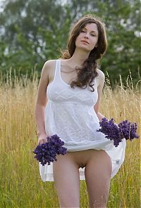 Babes: young curly brunette girl in the nature on the field of wild flowers