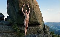 Babes: cute young blonde girl with a navel piercing posing naked on rocks in high mountains