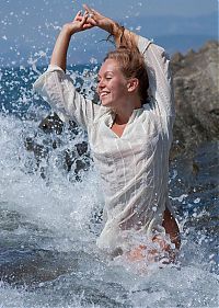 Nake.Me search results: young blonde girl undresses her white blouse on the rocky shore at the sea