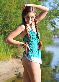 Babes: young brunette girl with pigtails undresses her blue chemise on the bank of the river