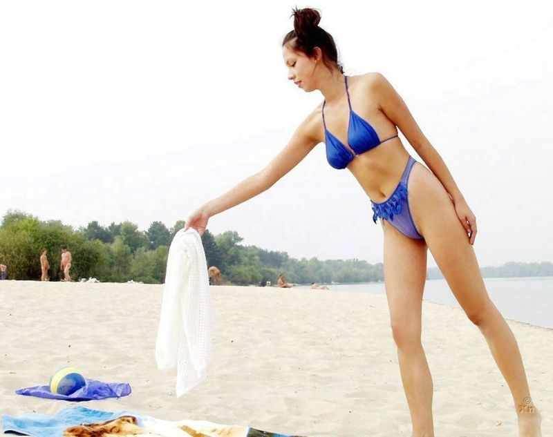 brunette girl on beach in blue swimsuit