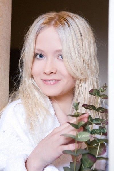 young blonde girl with blue eyes in bedroom