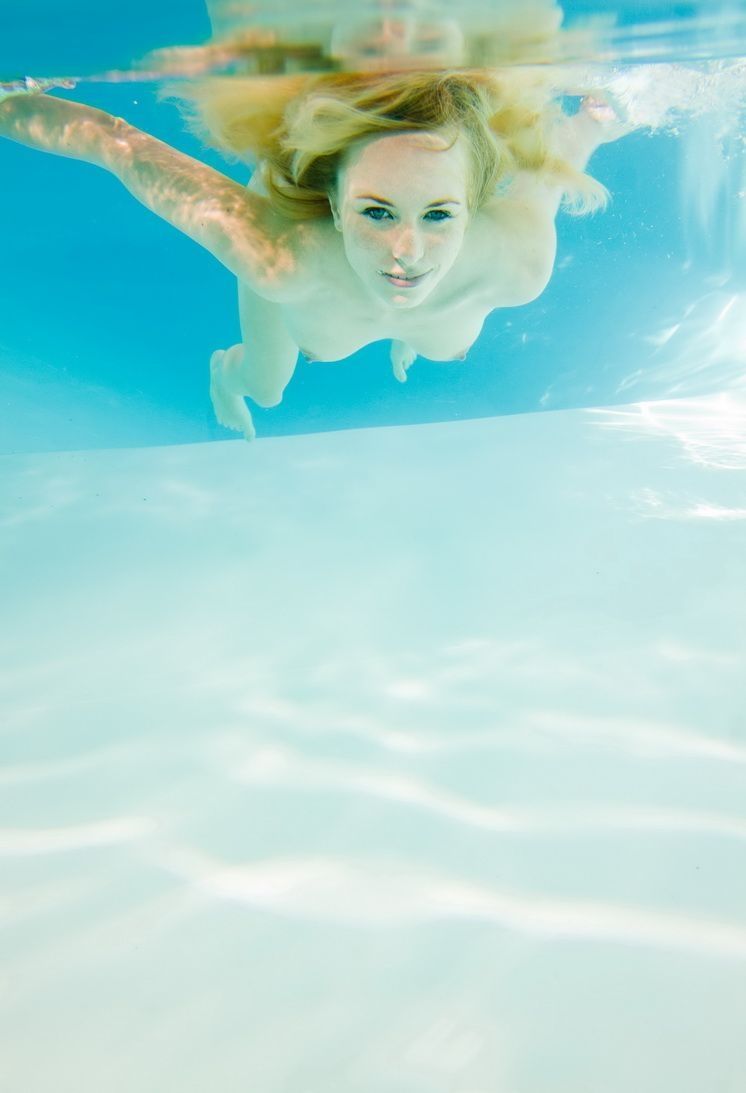 young reddish blonde girl enjoys the swimming pool