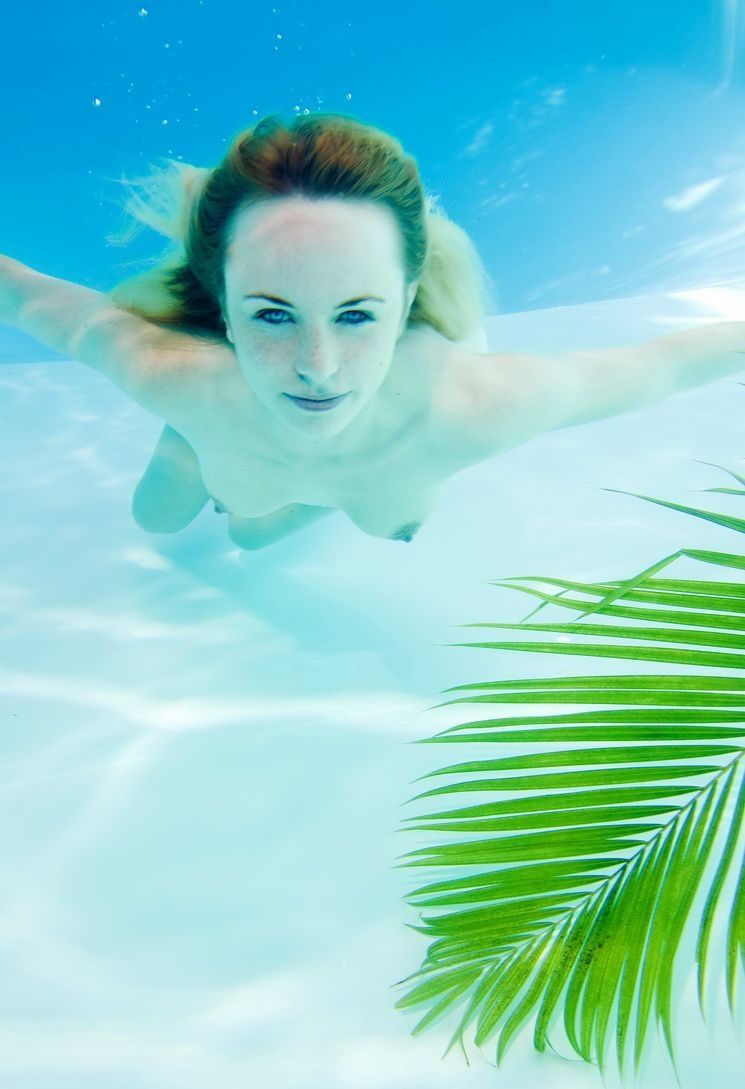 young reddish blonde girl enjoys the swimming pool