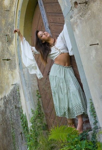 young brunette girl undresses in front of the castle's gate