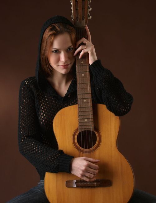 cute young red haired girl reveals with the guitar