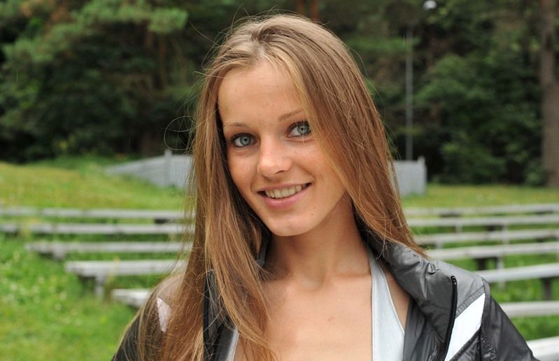 young brunette girl with long hair wearing silver pants on stairs