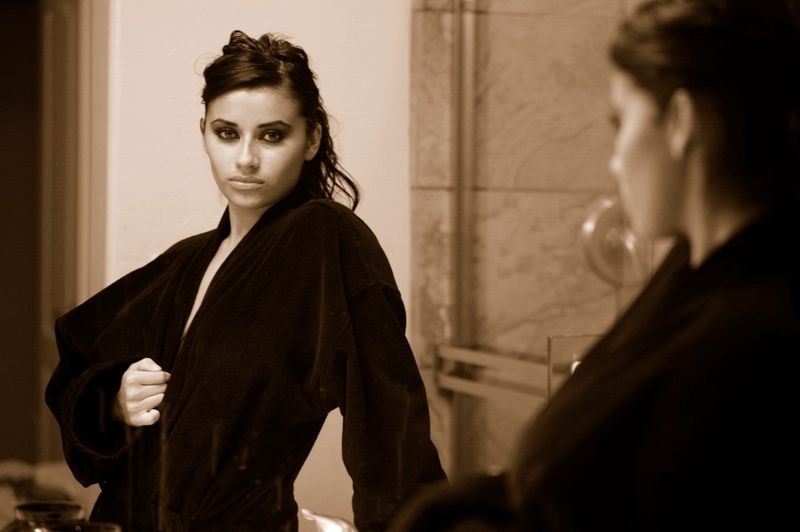 brunette girl wearing a bathrobe in the bathroom