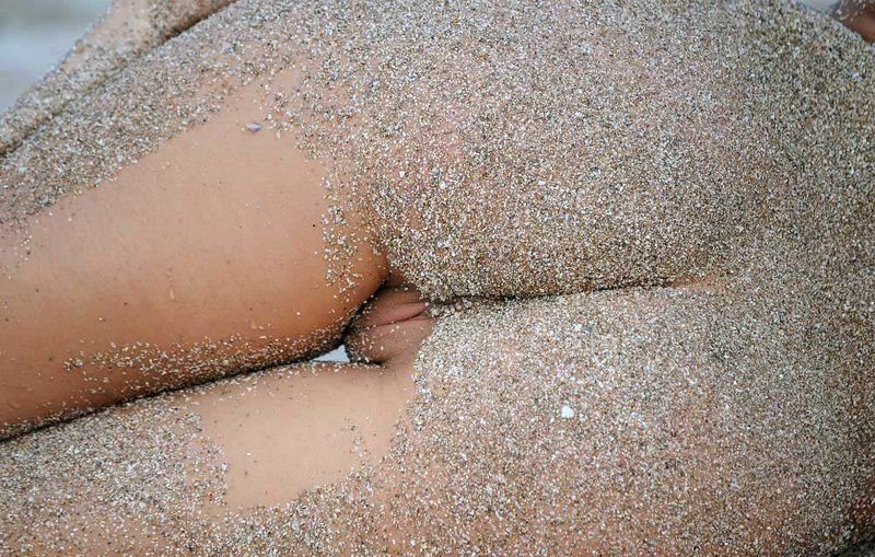 young curly brunette girl on the beach in the sand