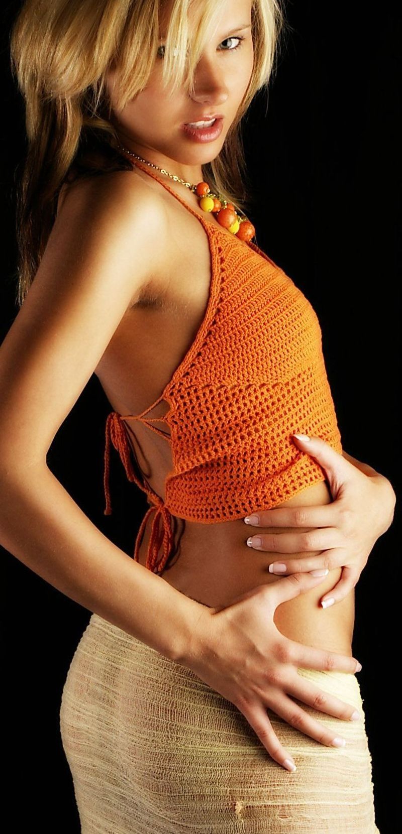 young blonde girl wearing orange knit shirt