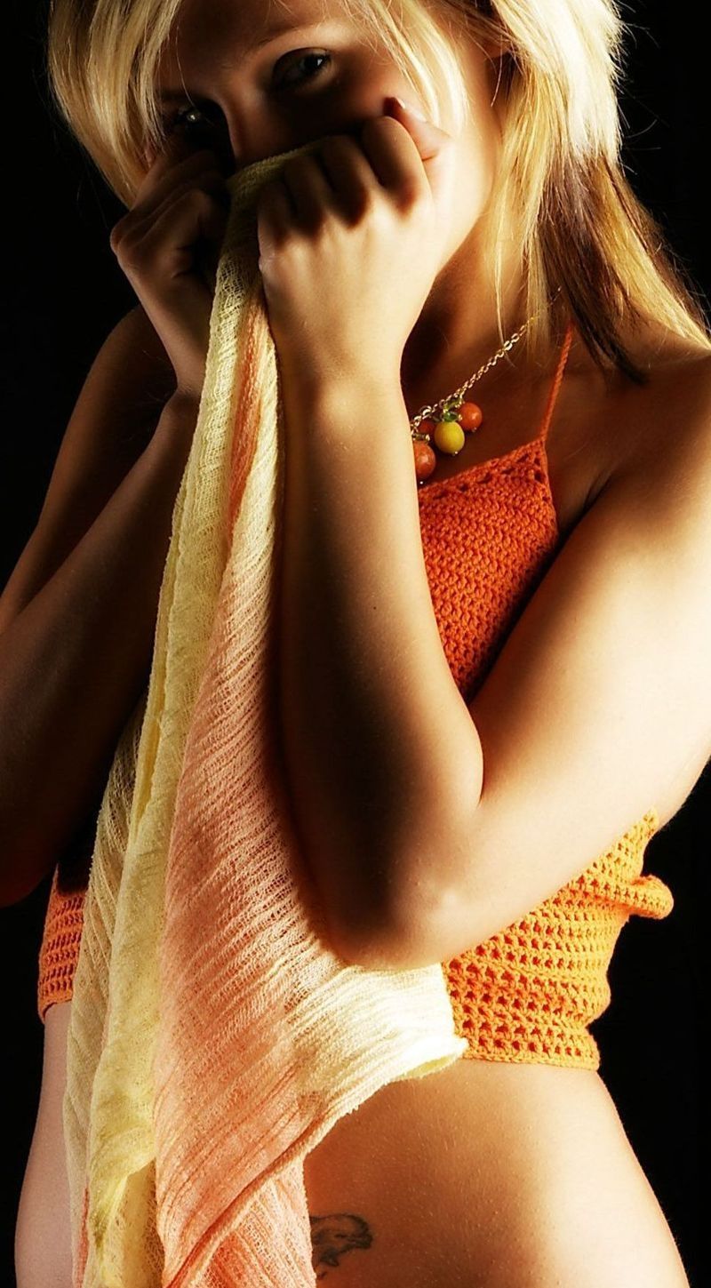 young blonde girl wearing orange knit shirt