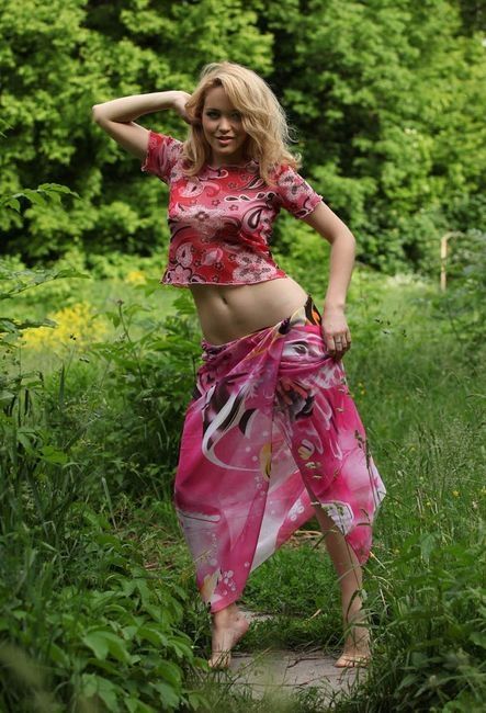 young blonde girl reveals in the nature on the forest glade