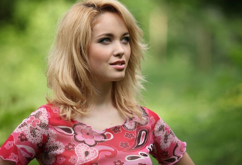 young blonde girl reveals in the nature on the forest glade