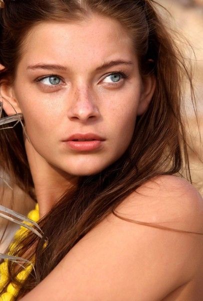 young brunette girl with blue eyes and a yellow necklace