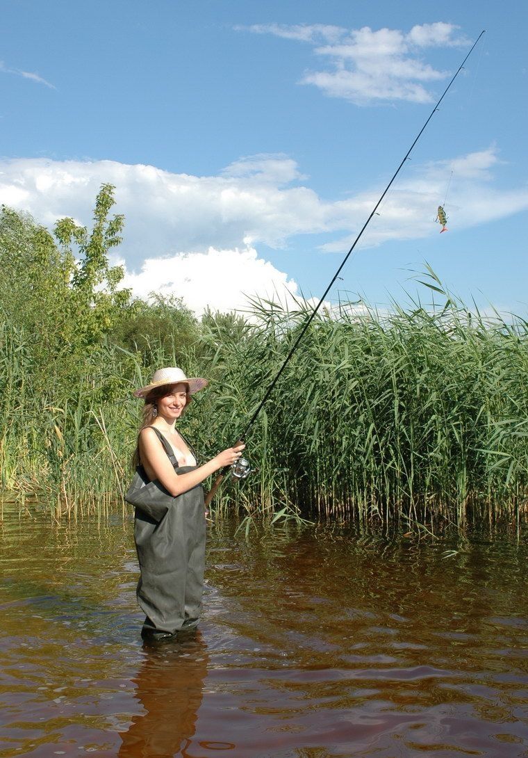 young brunette fish girl fishing in the swampland