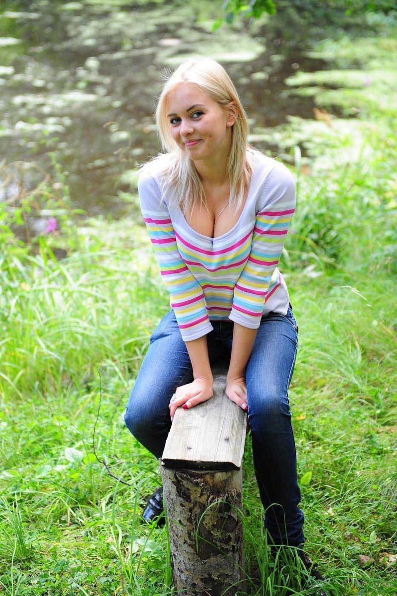 young blonde girl outside on the wooden bench