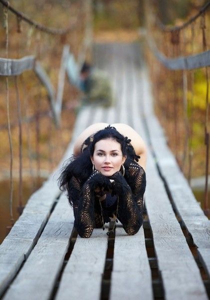 black haired girl in black on the old bridge