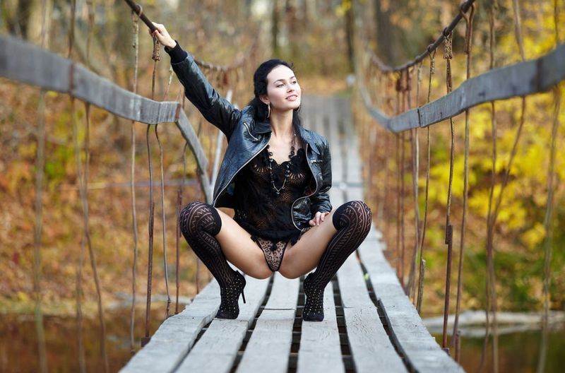 black haired girl in black on the old bridge