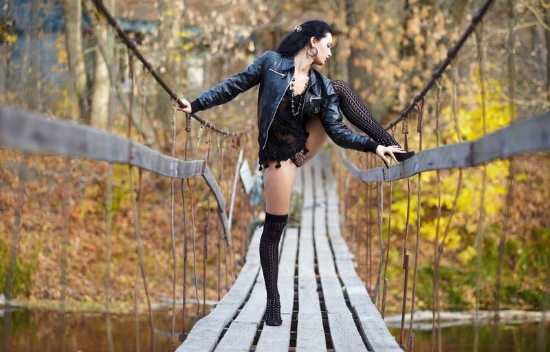 black haired girl in black on the old bridge