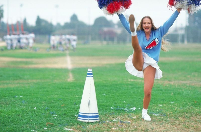 young blonde girl warms-up with exercises on the playground