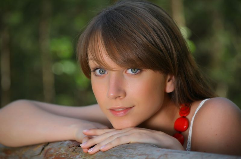 young brunette girl near the red wooden gate