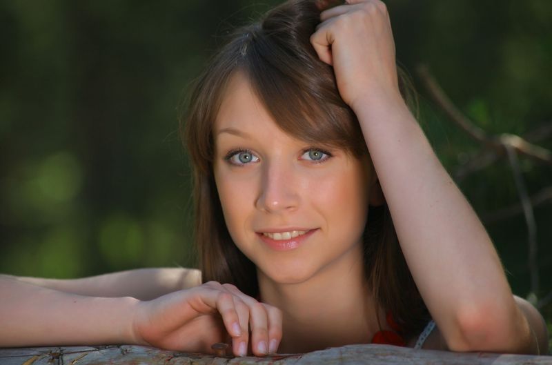 young brunette girl near the red wooden gate