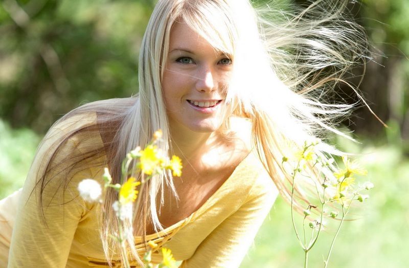 young blonde girl outside in the nature with yellow t-shirt
