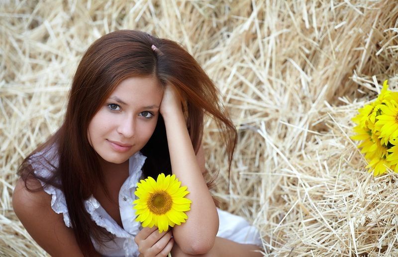 cute young brunette girl on the hay