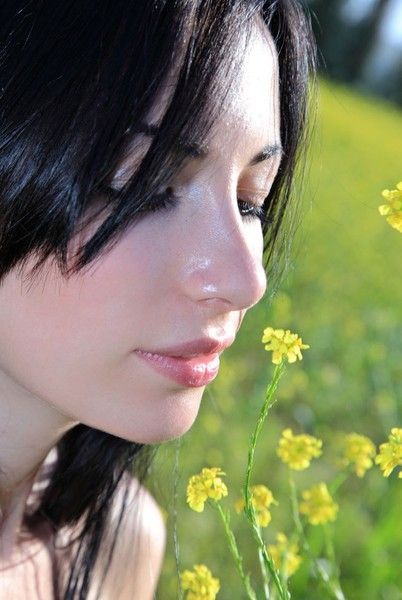 black haired girl on the field with yellow flowers