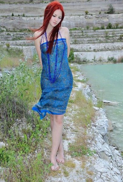 young red haired girl by the lake with blue necklace