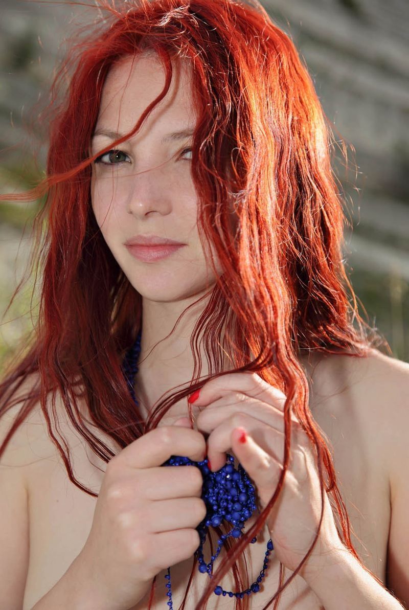 young red haired girl by the lake with blue necklace