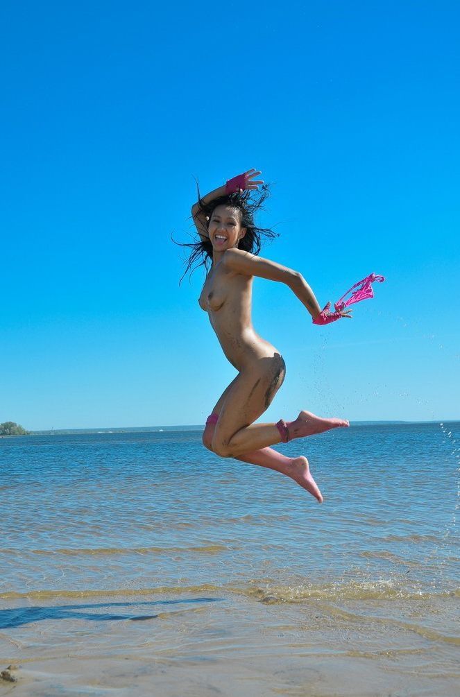 young black haired girl on the beach in a pink underwear