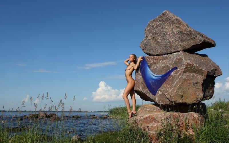 young dark blonde girl on rocks with a blue scarf