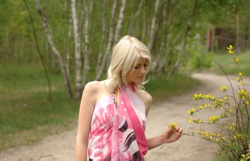 cute young blonde girl in the nature near a forest trail