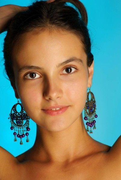 cute young brunette girl reveals in the studio with a textile fabric