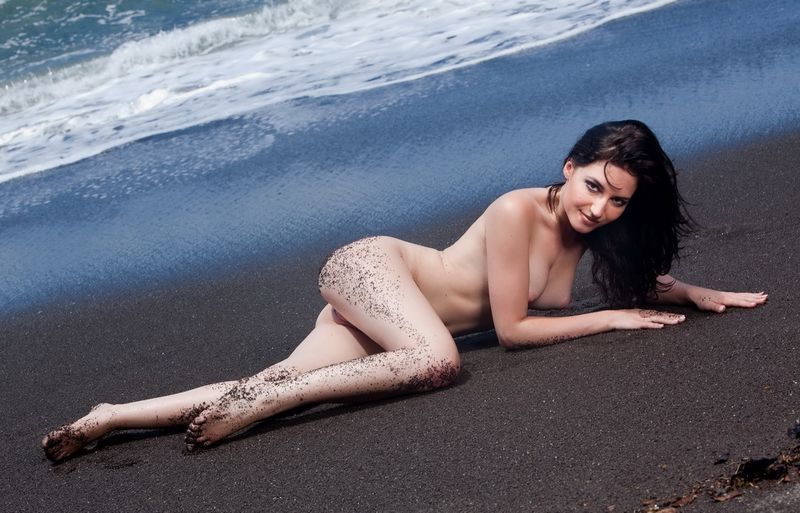 brunette girl on the beach with black sand