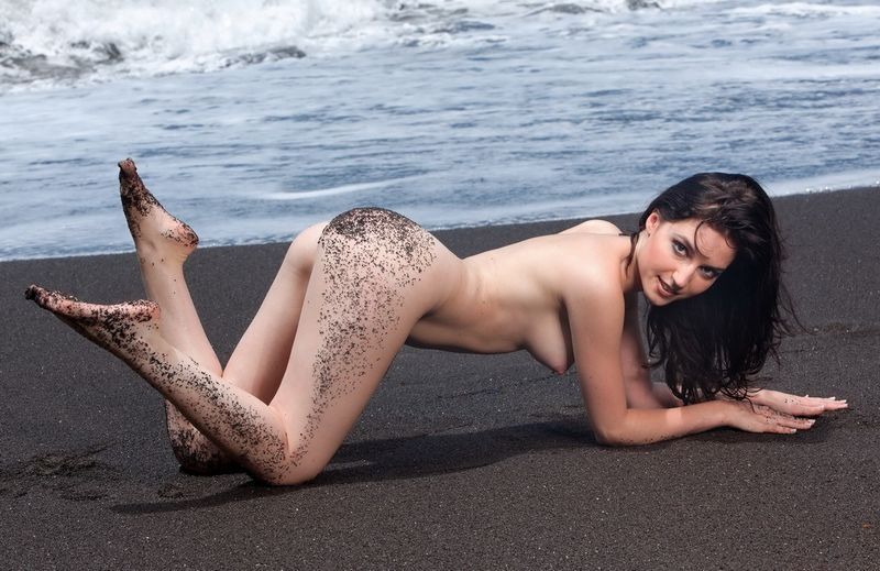 brunette girl on the beach with black sand