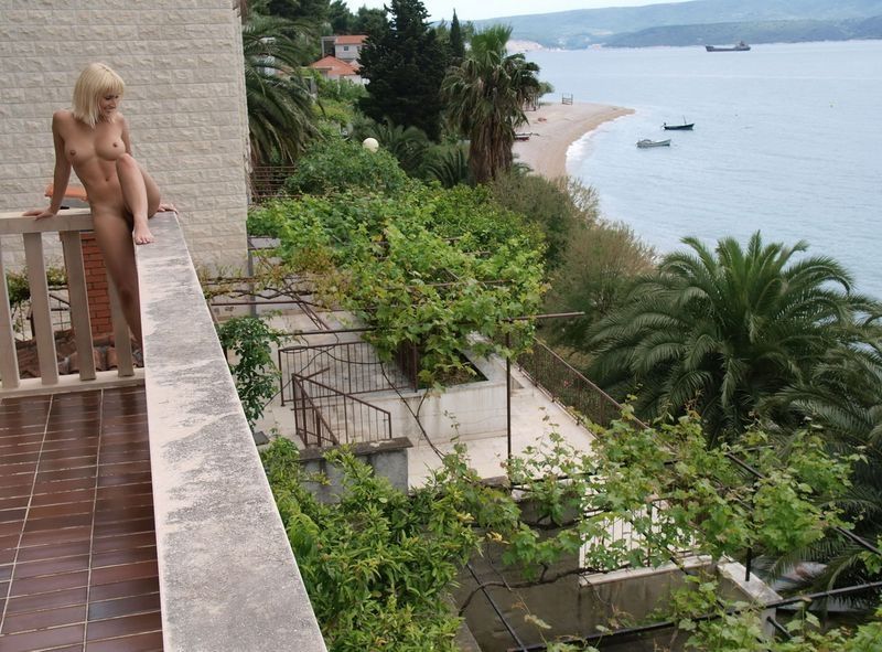 young blonde girl on the balcony with a sea view
