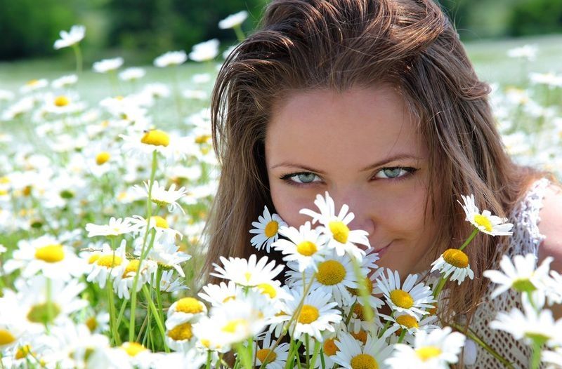 brunette girl on the field of daisy flowers