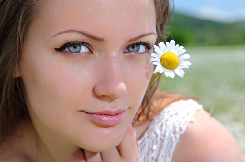 brunette girl on the field of daisy flowers