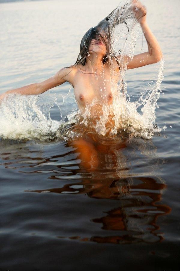 young brunette girl taking photos in the sea